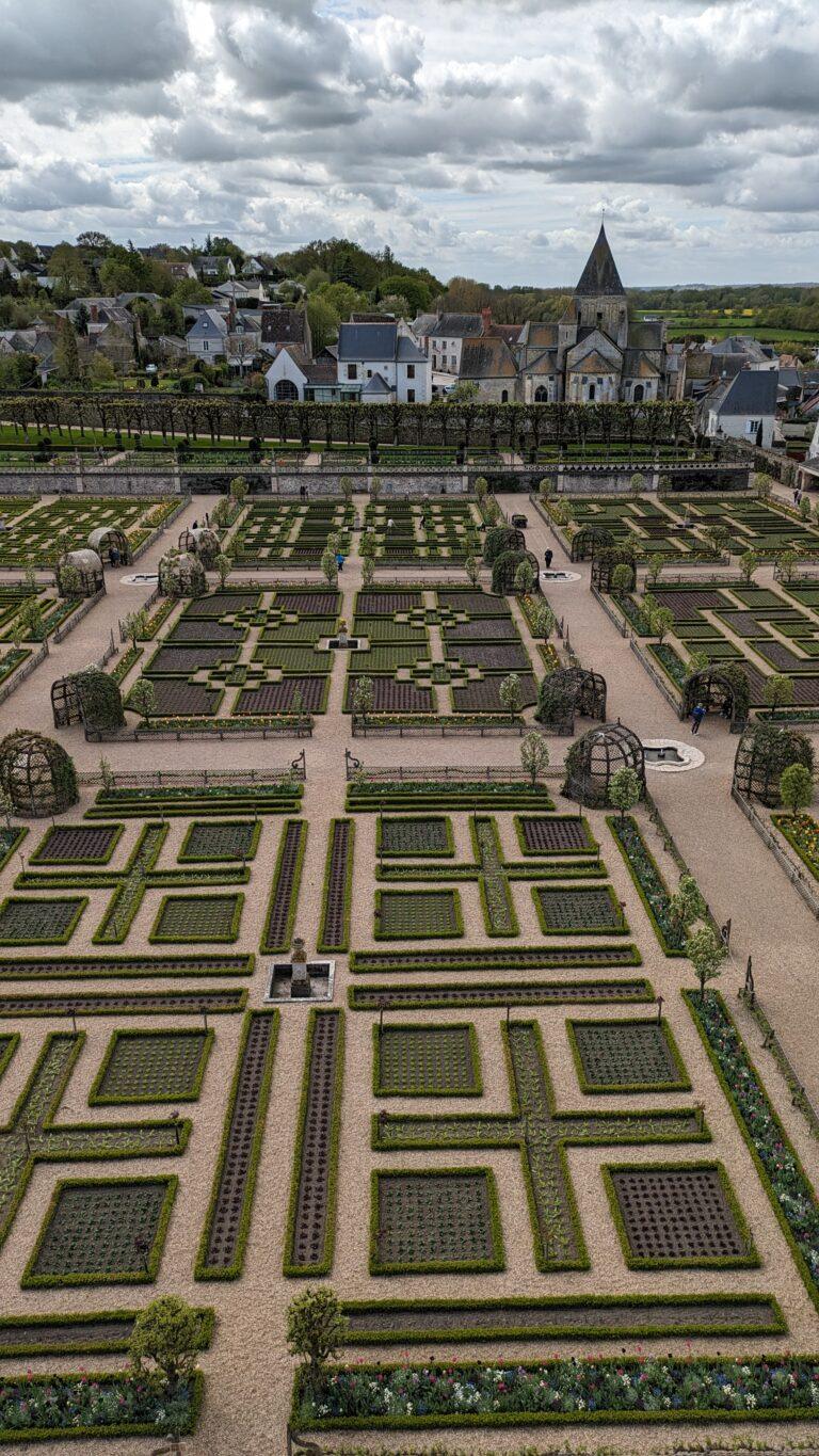 Villandry Castle Loire Valley aerial view with gardens, Renaissance ornamental gardens at Château de Villandry geometric patterns, Villandry water garden with fountains and reflective pools, Château de Villandry vegetable garden colorful seasonal plants, Villandry castle façade with Renaissance architecture, Château de Villandry terrace view overlooking formal gardens, Villandry herb garden with neatly arranged sections, Sunset at Villandry Castle golden light on the gardens, Visitors walking through Villandry Castle grounds, Château de Villandry in spring tulips and vibrant flowers, A Day at Villandry Castle: Where Gardens Steal the Show
