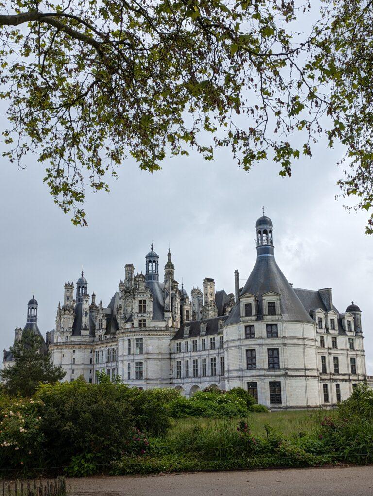A Day at Château de Chambord: The Crown Jewel of the Loire Valley, Château de Chambord aerial view Loire Valley largest castle, Chambord Castle double helix staircase designed by Leonardo da Vinci, Château de Chambord façade with Renaissance and medieval architecture, Chambord Castle rooftop terraces with chimneys and spires, Château de Chambord grand entrance courtyard with visitors, Interior of Chambord Castle ornate ceiling and stone carvings, Château de Chambord reflected in moat at sunrise, Chambord Castle hunting lodge history exhibition room, Château de Chambord gardens and surrounding forest, Night view of Chambord Castle illuminated against dark sky