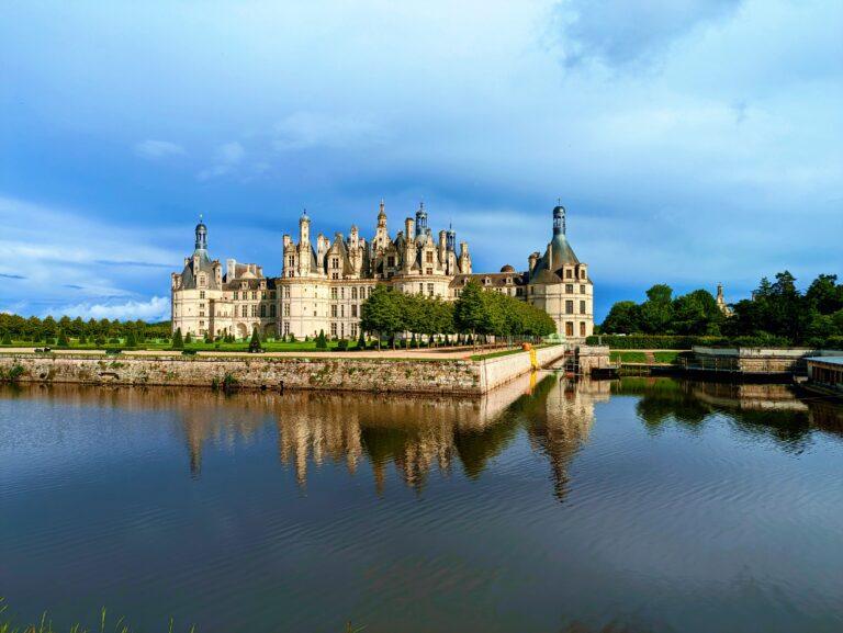 A Day at Château de Chambord: The Crown Jewel of the Loire Valley, Château de Chambord aerial view Loire Valley largest castle, Chambord Castle double helix staircase designed by Leonardo da Vinci, Château de Chambord façade with Renaissance and medieval architecture, Chambord Castle rooftop terraces with chimneys and spires, Château de Chambord grand entrance courtyard with visitors, Interior of Chambord Castle ornate ceiling and stone carvings, Château de Chambord reflected in moat at sunrise, Chambord Castle hunting lodge history exhibition room, Château de Chambord gardens and surrounding forest, Night view of Chambord Castle illuminated against dark sky