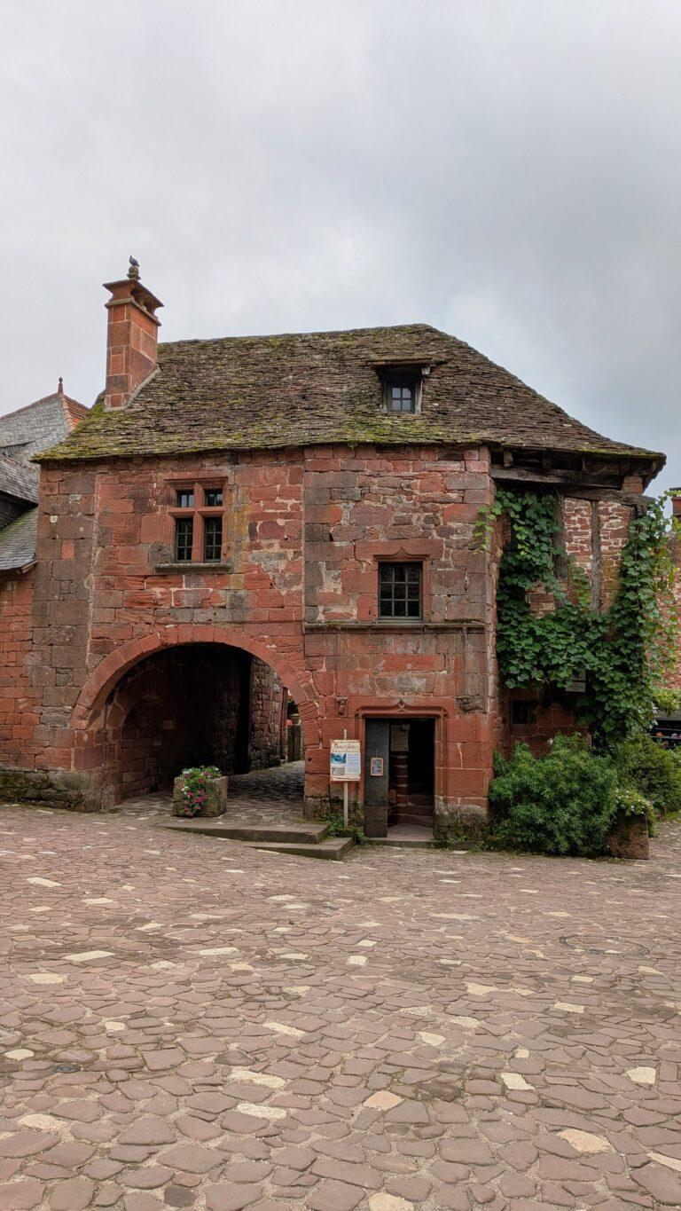 Maison de la Sirène, Collonges-la-Rouge, red stone house, medieval carving,Collonges-la-Rouge: The Red Stone Gem of France, Collonges-la-Rouge village, red sandstone houses, medieval architecture, Limousin France, Collonges-la-Rouge alley, red stone walls, flowered balconies, charming street, saru's postcards, beautiful villages of France