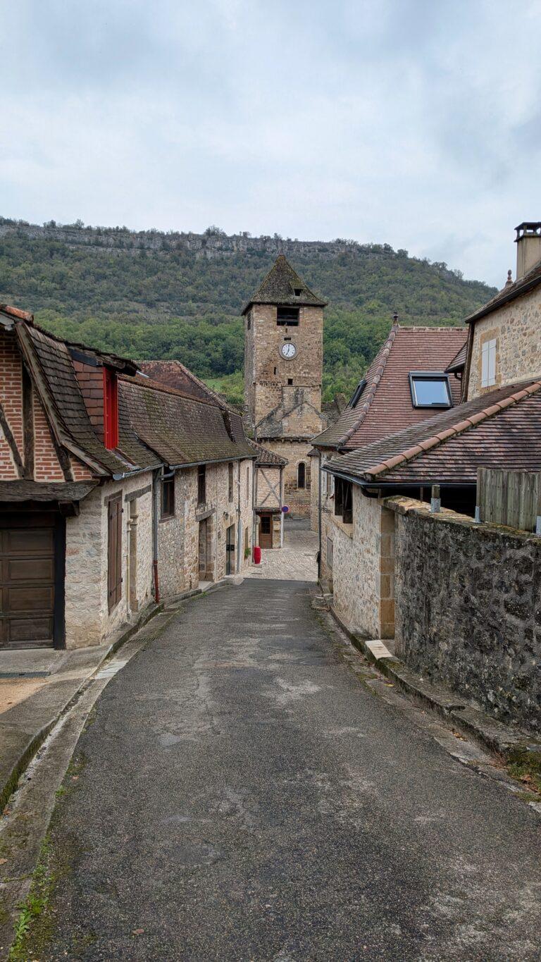 aint-Pierre church Autoire, Romanesque architecture, stone bell tower, autoire village, golden stone houses, medieval architecture, lot region, france autoire valley, limestone cliffs, picturesque landscape, south west france autoire rooftops, panoramic view, charming french village, countryside scenery, saru's postcards, French village, Autoire: The Little Versailles of the Lot