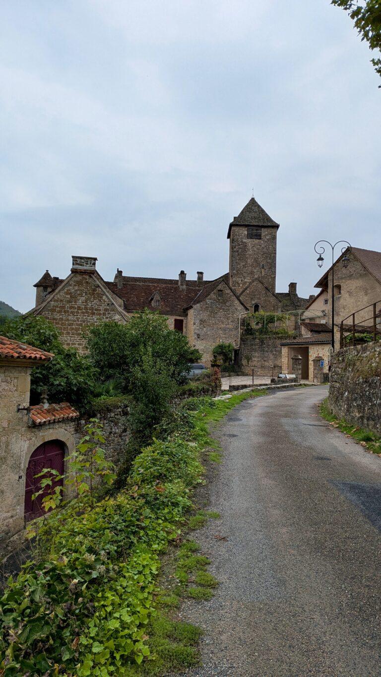 aint-Pierre church Autoire, Romanesque architecture, stone bell tower, autoire village, golden stone houses, medieval architecture, lot region, france autoire valley, limestone cliffs, picturesque landscape, south west france autoire rooftops, panoramic view, charming french village, countryside scenery, saru's postcards, French village, Autoire: The Little Versailles of the Lot