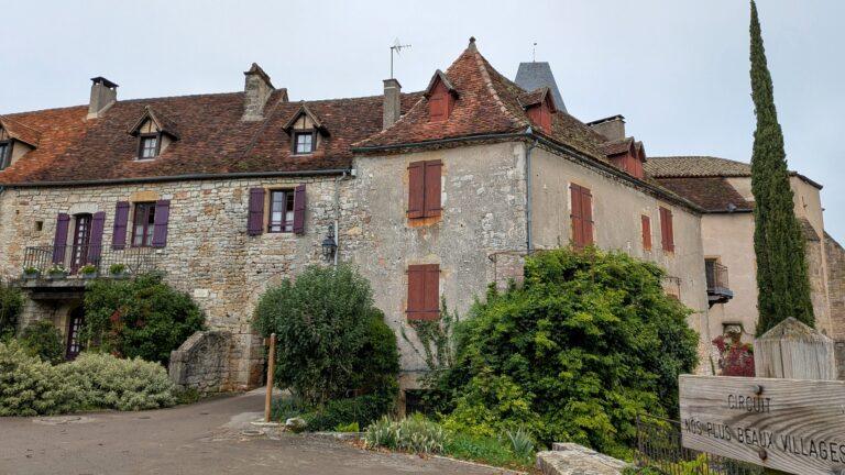 Loubressac: The Hilltop Jewel of the Lot Valley, saru's postcards, church of saint jean baptiste loubressac, romanesque church, historic building, village center, france chateau de loubressac, stone castle, hilltop fortress, panoramic view, French heritage, loubressac viewpoint, valley view, dordogne valley, scenic landscape, lot region lot valley from loubressac, rolling hills, green fields, beautiful france, countryside view, loubressac houses, flowered balconies, limestone walls, charming details, travel destination old wooden door loubressac, rustic french house, village charm, historical architecture, loubressac sunset, golden light, picturesque rooftops, lot countryside, magical moment morning in loubressac, sunlight on stone houses, peaceful atmosphere, hidden gem france village lane loubressac, flowers and ivy, romantic walk, travel photography, postcard moment